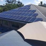 home wit solar panels and shade sails between